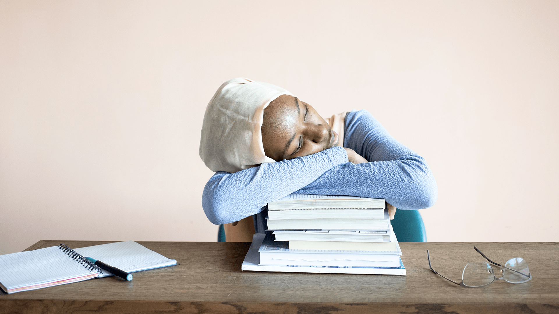 African American girl asleep atop textbooks
